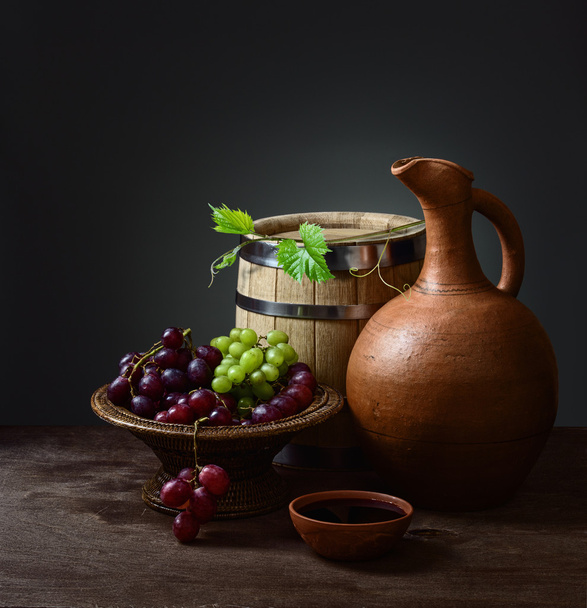 bowl with red wine pitcher with a barrel and grapes - Photo, Image