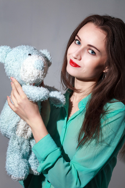 Girl in the turquoise shirt with a blue teddybear - Fotoğraf, Görsel