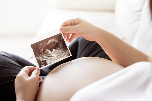 Pregnant woman with ultrasound scan picture  - Foto, Bild