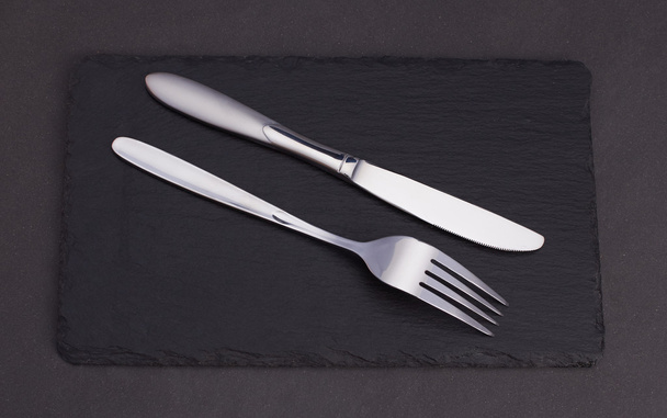 cuchillo y tenedor en basalto
 - Foto, Imagen