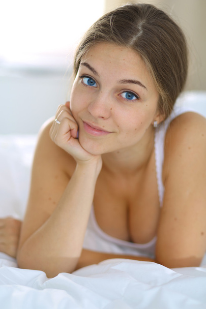 A beautiful young woman lying in bed comfortably and blissfully - Foto, immagini