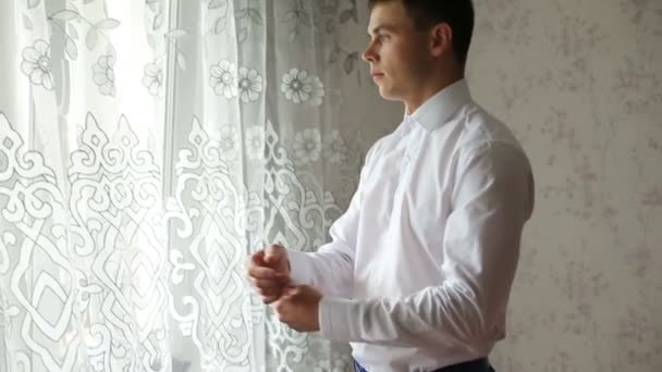 Homme boutonnant une chemise blanche
 - Séquence, vidéo