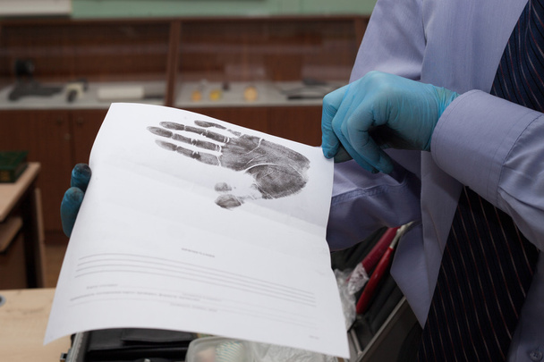 Expert looks at the paper with the imprint of his hands. - Photo, Image