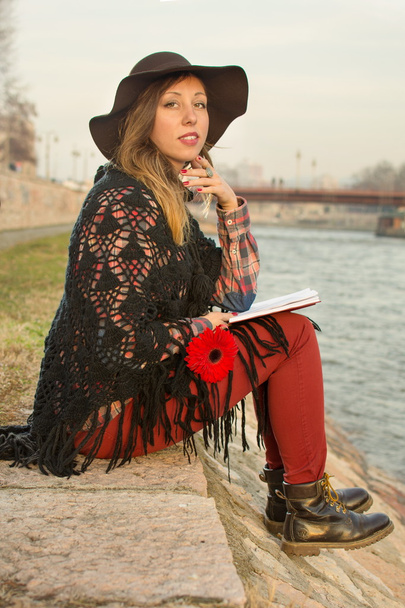 Brunette fille avec un livre au bord de la rivière
 - Photo, image