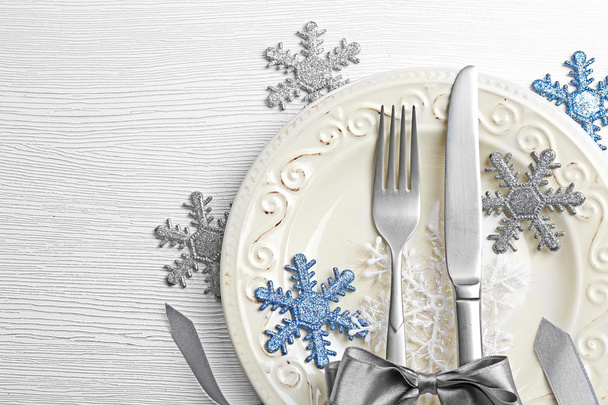 Christmas serving cutlery on plate over light wooden table, close up - Фото, изображение
