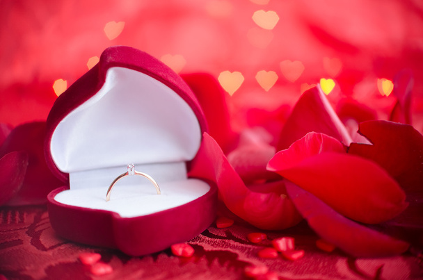 Eljegyzési gyűrű és a piros rózsaszirom - Fotó, kép