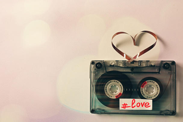 Retro audio cassette with tape in shape of heart on white background - Photo, Image