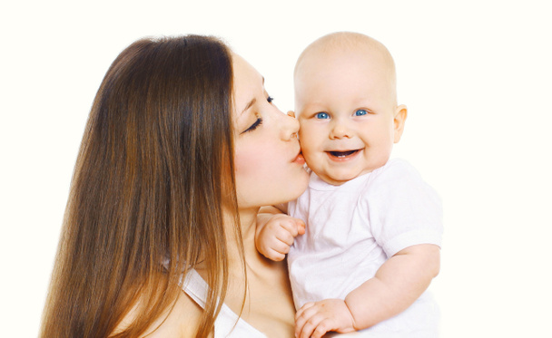 Portrait mère heureuse embrassant son bébé mignon sur fond blanc
 - Photo, image