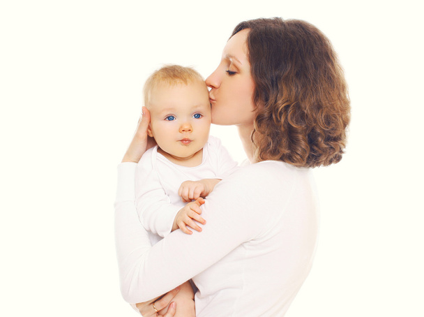 Portrait d'une mère heureuse et aimante embrassant son bébé sur un dos blanc
 - Photo, image