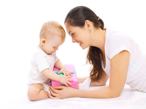 Happy smiling mother and baby with gift box on a white backgroun - Φωτογραφία, εικόνα