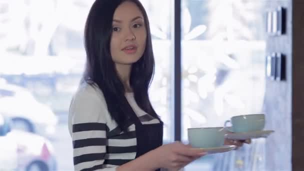 eine charmante Barista bringt Kaffee - Filmmaterial, Video