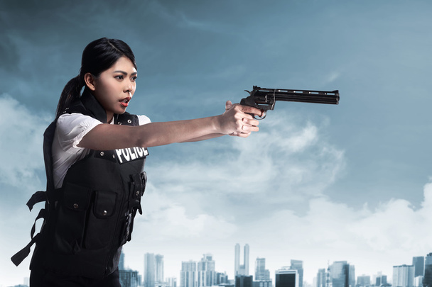 Beautiful police woman holding gun - Foto, afbeelding