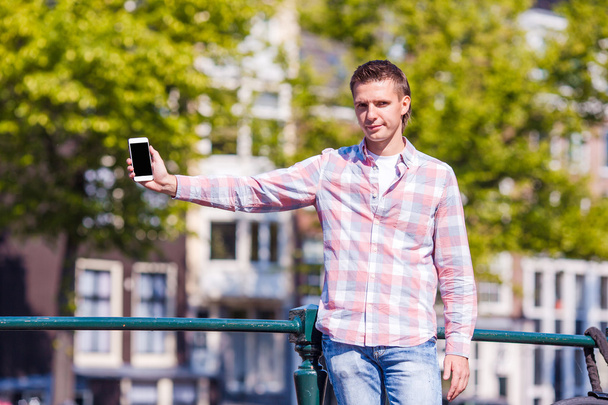 Giovane uomo caucasico con telefono nella città europea
 - Foto, immagini