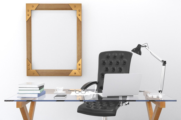 Work desk with a laptop and a blank picture frame on the wall, m - Photo, Image