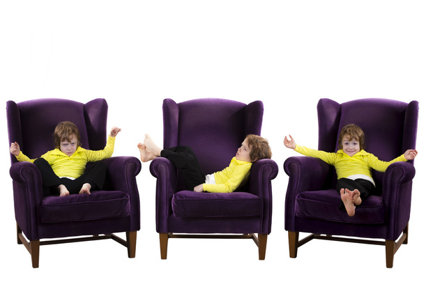 3 つの紫のアームチェアに座って退屈、幸せ、怒りの赤髪少年 - 写真・画像