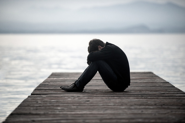 Sad man on a dock - Foto, Bild