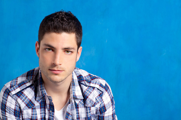 Handsome young man with plaid shirt on blue - Zdjęcie, obraz