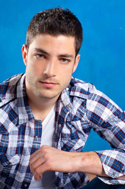 Handsome young man with plaid shirt on blue - 写真・画像