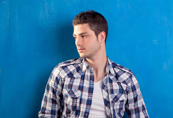 Handsome young man with plaid shirt on blue - 写真・画像