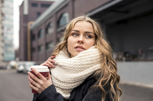 Teenage woman holding a cup of hot drink outdoors - Foto, imagen