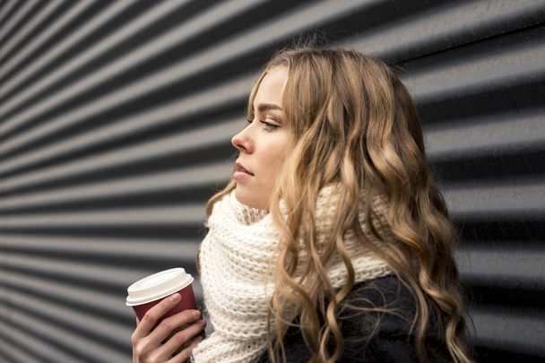 blonde with coffee on a black striped background - Zdjęcie, obraz