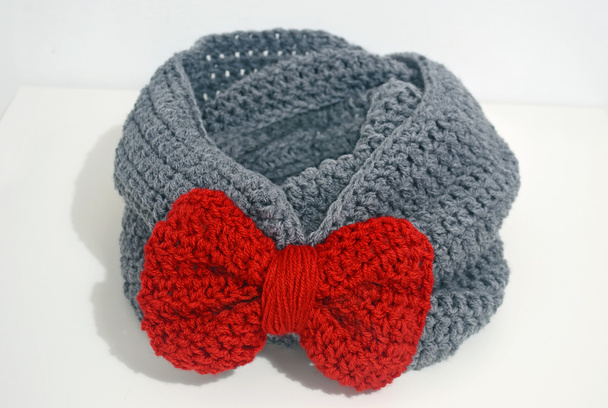 bufanda de ganchillo gris con lazo rojo
 - Foto, imagen