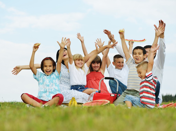 Gezin met kinderen hebben picnic tijd op groene weide - Foto, afbeelding