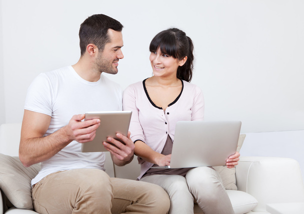 Young couple using laptops in couch - Foto, immagini