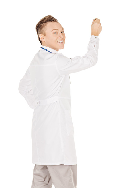 Young  male doctor in white coat writing on blank glass board or - Foto, immagini