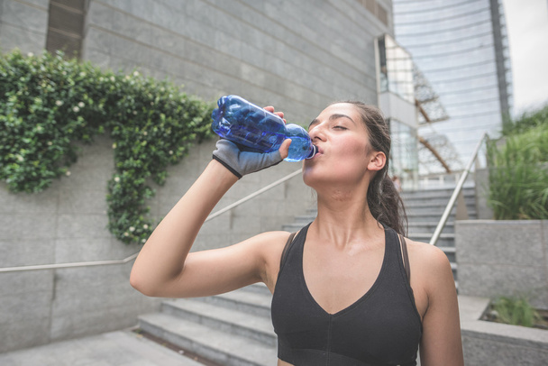 sportive woman drinking water - Photo, Image