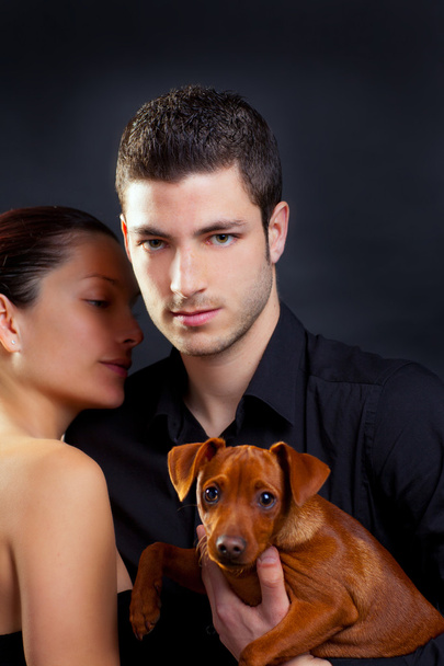 Couple in love with brown little pet puppy dog - Fotografie, Obrázek