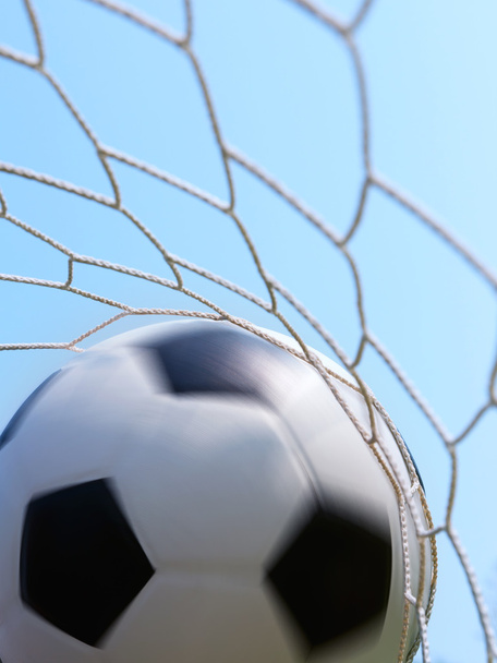 Voetbal spinnen in doel tegen blauwe hemel - Foto, afbeelding