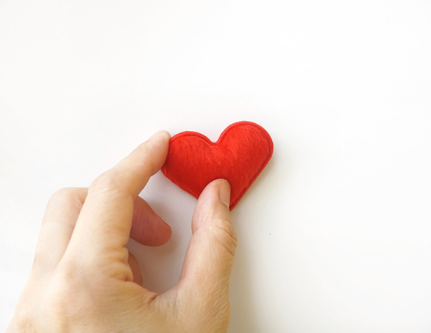 hand put red heart on white background - Foto, Imagen