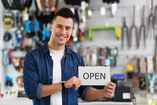 Man holding open sign in bike shop - Photo, Image