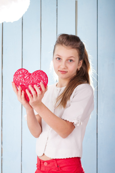 Chica sosteniendo el corazón rojo y mirando a la cámara
 - Foto, Imagen