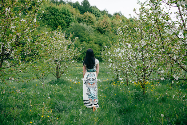 Frühlingsspaziergang Mädchen in einem schönen Kirschgarten - Foto, Bild