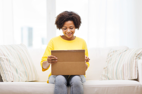 happy african young woman with parcel box at home - Fotoğraf, Görsel