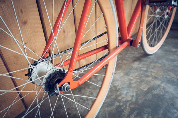 bicicleta de engrenagem fixa estacionada com parede de madeira, imagem de close-up
 - Foto, Imagem