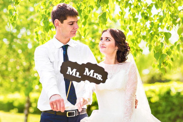 Noiva e noivo engraçados com os sinais do Sr. e da Sra.. Feliz dia do casamento
 - Foto, Imagem
