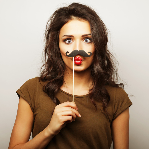 Young woman wearing fake mustaches. - Foto, afbeelding