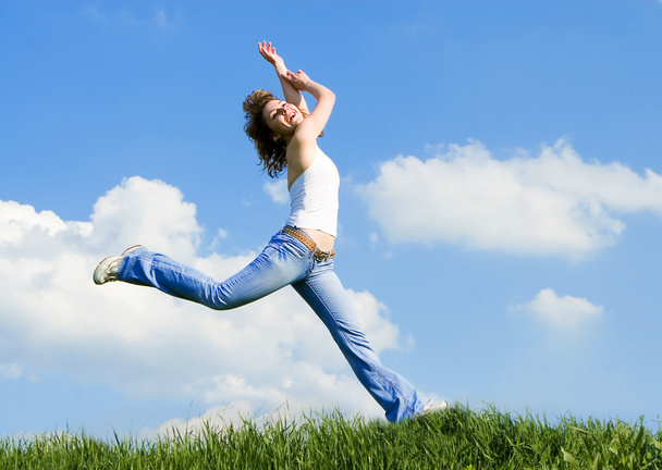 Heureuse jeune femme sautant dans l'herbe verte
 - Photo, image