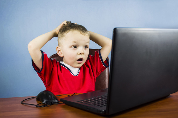 boy plays at a laptop - Φωτογραφία, εικόνα
