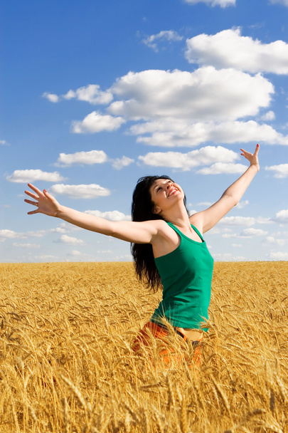 Happy woman jumping in golden wheat - Photo, Image