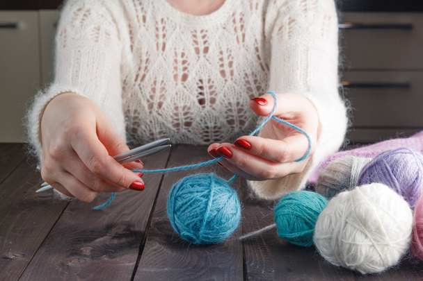 woman is knitting on a kitchen table - Zdjęcie, obraz