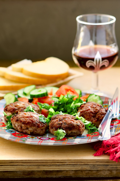 Баранина і телятина котлети зі свіжими овочами салат, хліб і келих вина
 - Фото, зображення