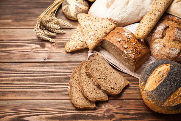 Ассортимент хлеба на деревянной поверхности
 - Фото, изображение