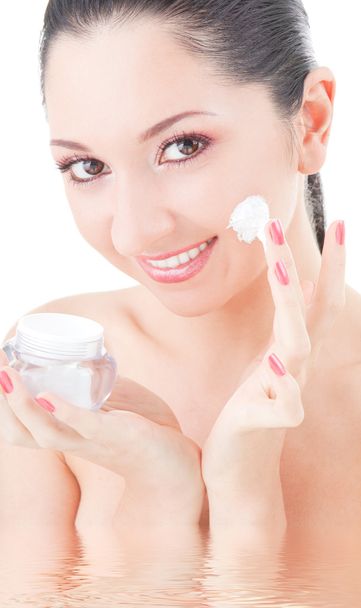 Woman applying cream to her face on the white background - Photo, Image