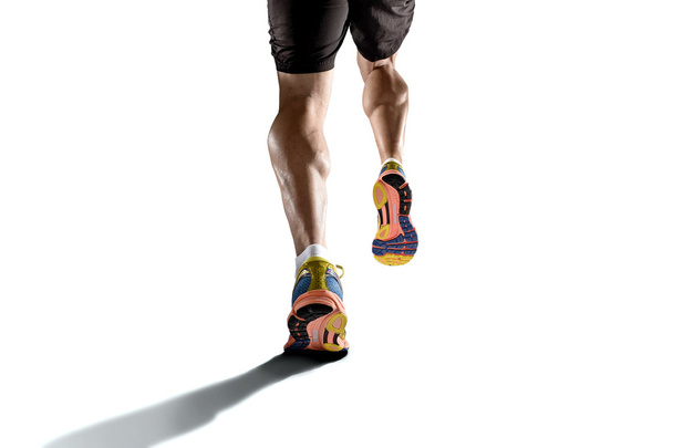 strong athletic legs with ripped calf muscle of young sport man running isolated on white background - Photo, image