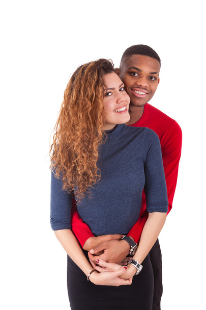 Happy mixed race couple hugging over a white background - Фото, изображение