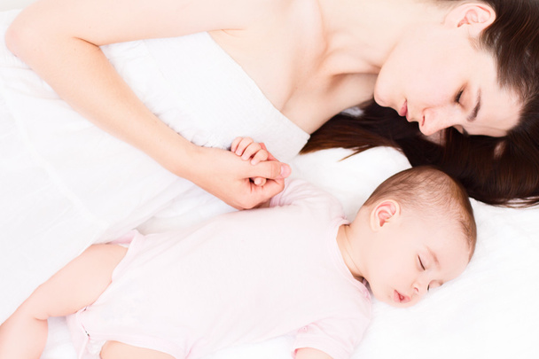 Adorable sleeping baby with mom on white background - Фото, изображение